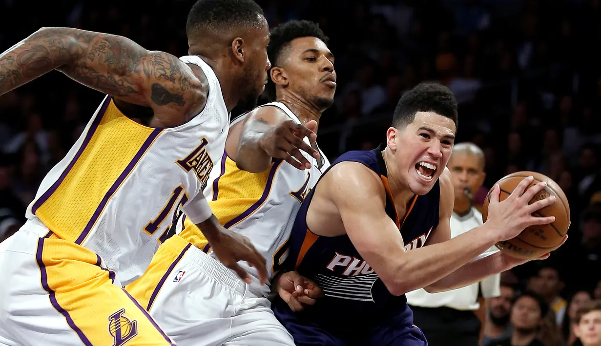  Pemain Los Angeles Lakers, Thomas Robinson (kiri) dan Nick Young (tengah), berusaha menghentikan serangan pemain Phoenix Suns, Devin Booker, dalam laga basket NBA di Staples Center, Los Angeles, Senin (7/11/2016) pagi WIB. (AP Photo/Alex Gallardo)