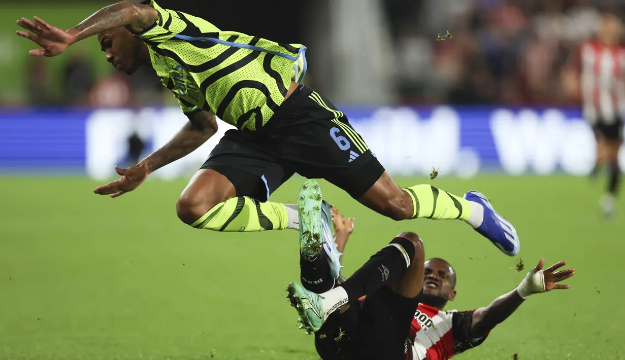 Bek Arsenal Gabriel (kiri) dijegal oleh gelandang  Brentford Frank Onyeka dalam laga putaran ketiga Carabao Cup 2023/2024 di Gtech Community Stadium, Kamis (28/9/2023) dini hari WIB. (AP Photo/Ian Walton)