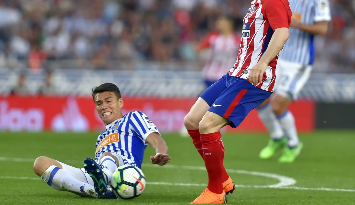 Bek Real Sociedad, Hector Moreno, merebut bola saat pertandingan melawan Atletico Madrid pada laga La Liga di Stadion Municipal de Anoeta, Kamis (19/4/2018). Real Sociedad menang 3-0 atas Atletico Madrid. (AFP/Ander Gillenea)