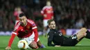 Gelandang Manchester United, Jesse Lingard, terjatuh berebut bola dengan pemain Midtjylland, Kian Hansen. Laga kedua tim berlangsung ketat dan keras. (Reuters/Russell Cheyne)