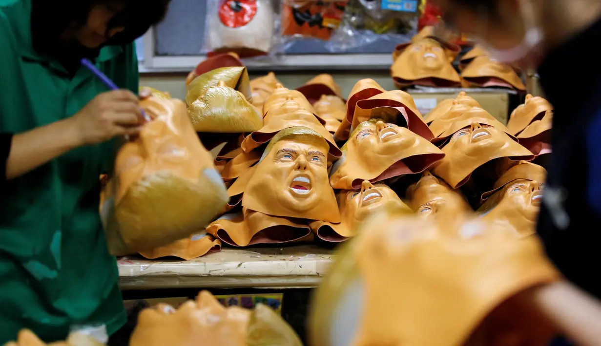 Pekerja menyelesaikan pembuatan topeng yang menyerupai wajah Donald Trump di Studio Ogawa, Saitama, Jepang (21/11). Ogawa Studios merupakan salah satu produsen pembuat topeng karet Trump yang cukup bergengsi di Jepang. (Reuters/Toru Hanai)