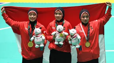 Tim pencak silat seni beregu putri Indonesia, Pramudita Yuristya (kiri), Lutfi Nurhasanah (tengah) dan Gina Tri Lestari (kanan) berpose usai meraih medali emas Asian Games 2018, Jakarta, Rabu (29/8). (ANTARA FOTO/INASGOC/Melvinas Priananda/nak/18)