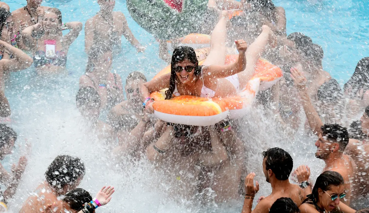 Seorang wanita menaiki ban karet saat berjoget di kolam renang selama Arenal Sound Music Festival 2019 di Burriana, Spanyol (31/7/2019). Festival musik ini berlangsung dari 30 Juli sampai 4 Agustus 2019.  (AFP Photo/Jose Jordan)