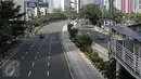 Pengendara melintasi jalan protokol yang lengang di kawasan MH Thamrin, Jakarta, Selasa (6/7). Hampir semua jalan di Ibu Kota lengang saat sebagian besar warga mudik untuk merayakan Lebaran di kampung halaman. (Liputan6.com/Faizal Fanani)