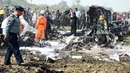 Sejumlah petugas  memeriksa lokasi jatuhnya pesawat militer sesaat setelah lepas landas dari Naypyidaw, Myanmar, Rabu (10/2). Ratusan orang berkumpul di lokasi kejadian, sementara petugas berusaha memadamkan api di badan pesawat.  (AFP/PHOTO/AUNG Htet)