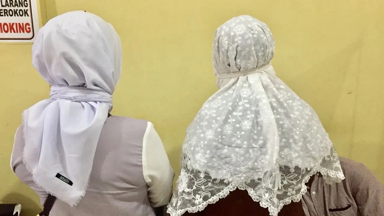 Dua wanita paruh baya asal Kabupaten Gowa tertangkap polisi diduga sedang menyusup ke dalam rombongan jemaah haji kloter 28 asal Kabupaten Gowa, Sulsel (Liputan6/ Eka Hakim)