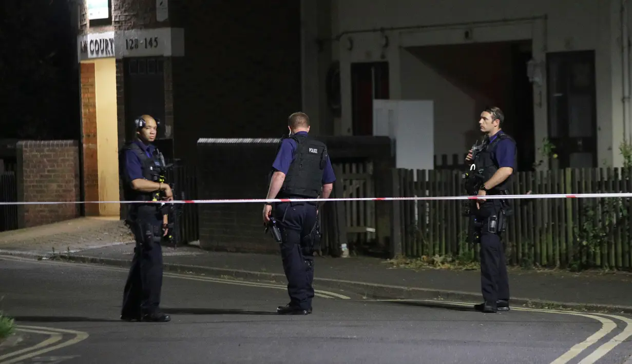 Sejumlah polisi berjaga dekat Seven Sisters Road di utara London usai insiden kendaraan yang menabraki pejalan kaki, Senin (19/6). Pihak kepolisian belum menyimpulkan apakah insiden ini sebagai kecelakaan atau serangan teroris. (Yui Mok/PA via AP)