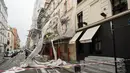 Pekerja melihat kerusakan yang terjadi usai penyangga proyek bangunan ambruk terkena angin kencang di Paris, Prancis (3/1). Tiang penyangga ini berjatuhan akibat terkena angin kencang dari badai Eleanor. (AFP Photo/Stephane De Sakutin)