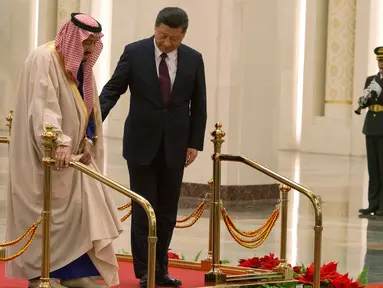  Presiden China Xi Jinping membantu Raja Arab Saudi Salman bin Abdulaziz al-Saud berjalan saat mengikuti upacara penyambutan di Beijing, China (16/3). (AP Photo / Ng Han Guan)