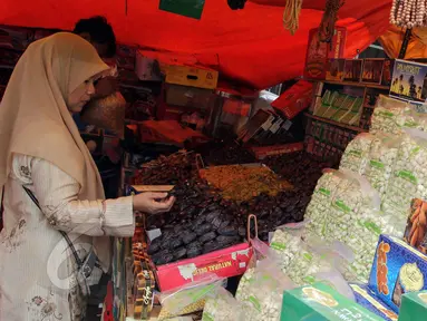 Seorang pembeli saat memilih buah kurma di pasar Tanah Abang, Jakarta, Selasa, (9/6/2015). Menjelang Ramadan Banyaknya pedagang kaki lima (PKL) yang menggelar dagangan di pinggir jalan menyebabkan daerah Tanah Abang macet. (Liputan6.com/Helmi Afandi)