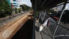 Penumpang bus transjakarta berjalan di samping pembangunan proyek underpass Matraman di Jakarta, Rabu (5/4). Proyek senilai Rp118 miliar itu ditargetkan selesai pada akhir 2017. (Liputan6.com/Immanuel Antonius)