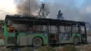Bangkai bus yang diserang dan dibakar oleh kelompok pemberontak saat dalam perjalanan ke al-Foua dan Kefraya di dekat Idlib, Suriah, Minggu (18/12). Bus itu sedianya untuk mengevakuasi warga yang sakit dan terluka di Aleppo timur. (REUTERS/Ammar Abdullah)