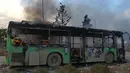 Bangkai bus yang diserang dan dibakar oleh kelompok pemberontak saat dalam perjalanan ke al-Foua dan Kefraya di dekat Idlib, Suriah, Minggu (18/12). Bus itu sedianya untuk mengevakuasi warga yang sakit dan terluka di Aleppo timur. (REUTERS/Ammar Abdullah)