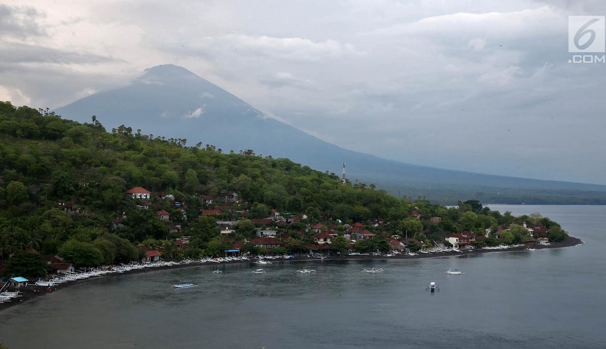 Lanskap Gunung Agung terlihat dari kawasan Pantai Amed, Karangasem, Bali, Rabu (6/12). Kawasan Amed menjadi salah satu lokasi favorit bagi wisatawan untuk menikmati matahari terbenam serta lansekap Gunung Agung. (Liputan6.com/Immanuel Antonius)