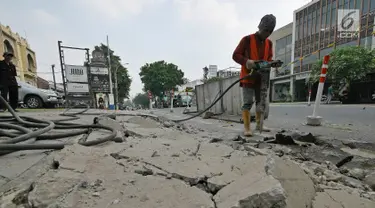 Pekerja menyelesaikan proyek revitalisasi trotoar di kawasan Kemang, Jakarta, Jumat (29/6/2019). Revitalisasi trotoar Kemang ditargetkan selesai pada November 2019. (Liputan6.com/Herman Zakharia)