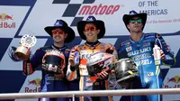 Pembalap Repsol Honda, Marc Marquez merayakan kemenangannya pada balapan MotoGP Amerika di samping Maverick Vinales dari Movistar Yamaha dan Andrea Iannone dari Suzuki Ecstar di podium Circuit of the Americas (COTA), Austin, Minggu (22/4). (AP/Eric Gay)