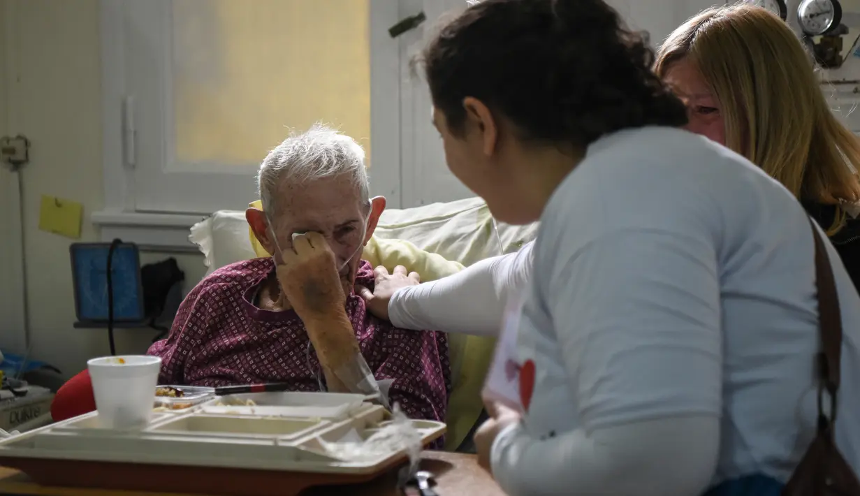 Ekspresi seorang pasien saat mendengarkan musik dari Musica Para el Alma yang tampil di Rumah Sakit Alvarez di Buenos Aires, Argentina (12/6). (AFP Photo/Eitan Abramovich)