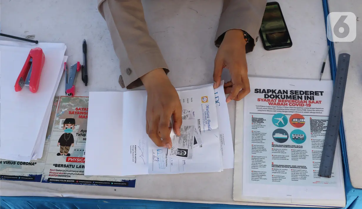 Petugas memeriksa kelengkapan dokumen penumpang yang menyeberang dengan kapal ferry di Pelabuhan Merak, Banten, Senin (18/5/2020). Penumpang harus memenuhi sejumlah persyaratan ketat mencakup standar kesehatan dan verifikasi dokumen guna memutus rantai penyebaran COVID-19 (Liputan6.com/Angga Yuniar)