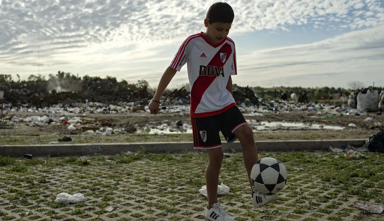 Daniel Dorado dari Argentina mengenakan jersey River Plate saat mengontrol bola di dekat rumahnya di daerah kumuh Costa Eperanza, Buenos Aires, 12 September 2020. Daniel, 12, yang bersekolah di sekolah sepak bola Angel Labruna bermimpi menjadi pesepak bola di klub River Plate (ARIEL TIMY TORRES/AFP)
