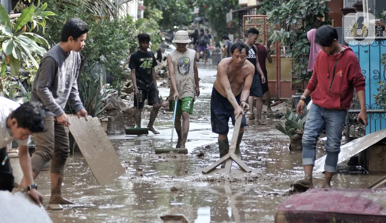 Sejumlah warga membersihkan lumpur di sekitar rumah usai banjir menerjang Perumahan Pondok Gede Permai, Jatiasih, Bekasi, Jawa Barat, Kamis (2/1/2020). Terjangan banjir setinggi lima meter tersebut menyisakan lumpur dan sampah yang memenuhi seluruh kompleks perumahan. (merdeka.com/Iqbal Nugroho)