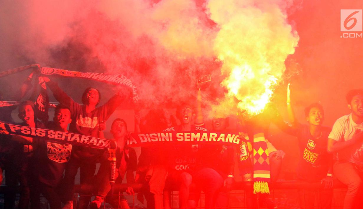 Suporter PSIS menyalakan suar saat merayakan kemenangan timnya melawan Martapura FC di Final tempat ketiga Liga 2 Indonesia di Stadion GBLA, Bandung, Selasa (28/11). PSIS unggul 6-4 dan lolos ke Liga 1 Indonesia. (Liputan6.com/Helmi Fithriansyah)