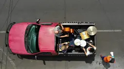 Band Maroto Jazz Trio yang terdiri dari Diego Maroto pada Saxophone, Jorge Molina pada double bass, dan Edy Vega pada drum tampil dari atas sebuah van melewati kawasan Mexico City, Meksiko, 29 Agustus 2020. Penampilan mereka dilakukan di tengah pandemi virus corona COVID-19. (RODRIGO ARANGUA/AFP)