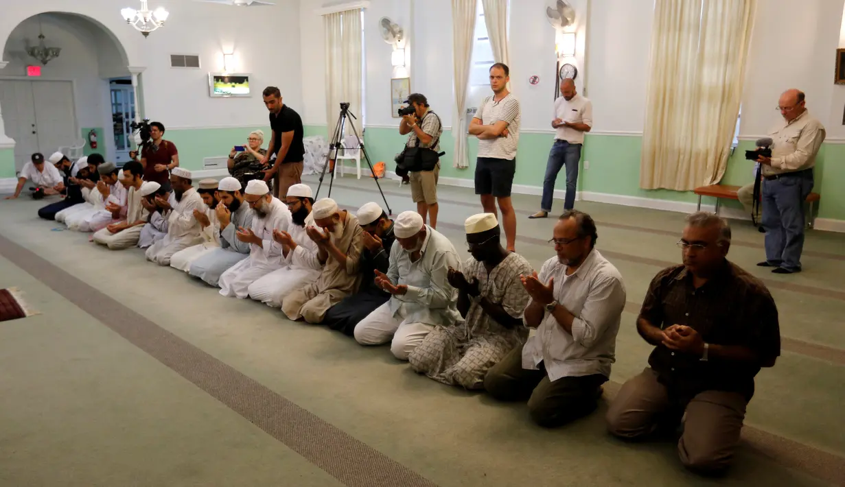 Komunitas muslim AS memanjatkan doa untuk para korban penembakan massal komunitas gay di Islamic Center of Fort Pierce, Fort Pierce, Florida, Minggu (12/6). (Reuters/Joe Skipper)