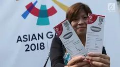 Salah satu calon penonton seremoni pembukaan Asian Games 2018 menunjukkan tiketnya jelang masuk kawasan GBK, Jakarta, Sabtu (18/8). Asian Games 2018 akan berlangsung hingga 2 September, mendatang. (Liputan6.com/Helmi Fithriansyah)