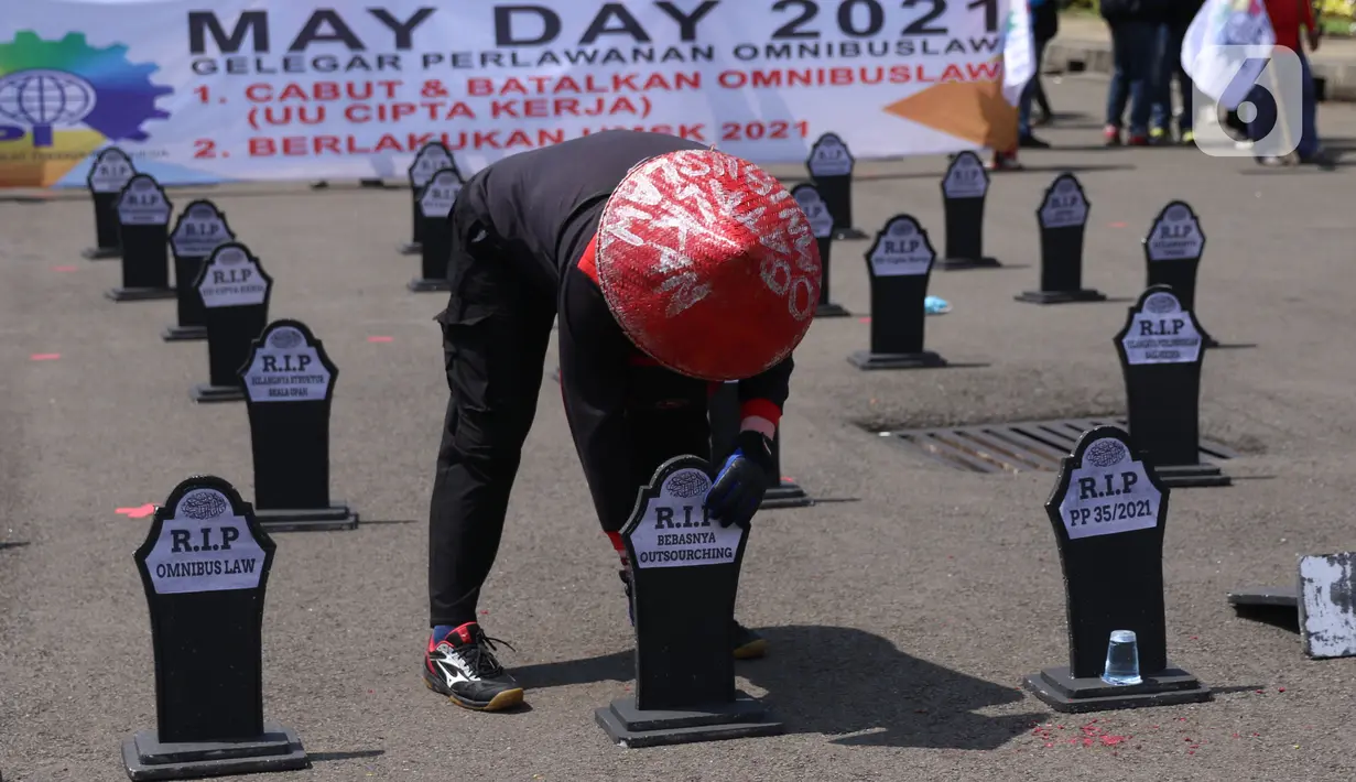 Buruh meletakkan puluhan nisan di sekitar area Monas, Jakarta, pada Hari Buruh Internasional, Sabtu (1/5/2021). Nisan hitam itu dihiasi tulisan yang mewakili perasaan para buruh, Antara lain RIP PHK Murah, Bebasnya Outsourcing, RIP Cuti Hamil, RIP Satuan Upah-Perjam. (Liputan6.com/Angga Yuniar)