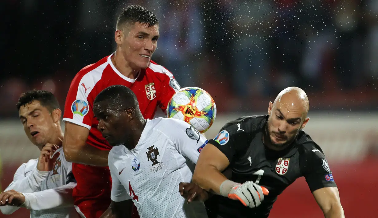 Gelandang Portugal, William Carvalho, bereut bola dengan kiper Serbia, Marko Dmitrovic, pada laga Kualifikasi Piala Eropa 2020 di Belgrade, Sabtu (7/9). Serbia kalah 2-4 dari Portugal. (AFP/Pedja Milosavljevic)