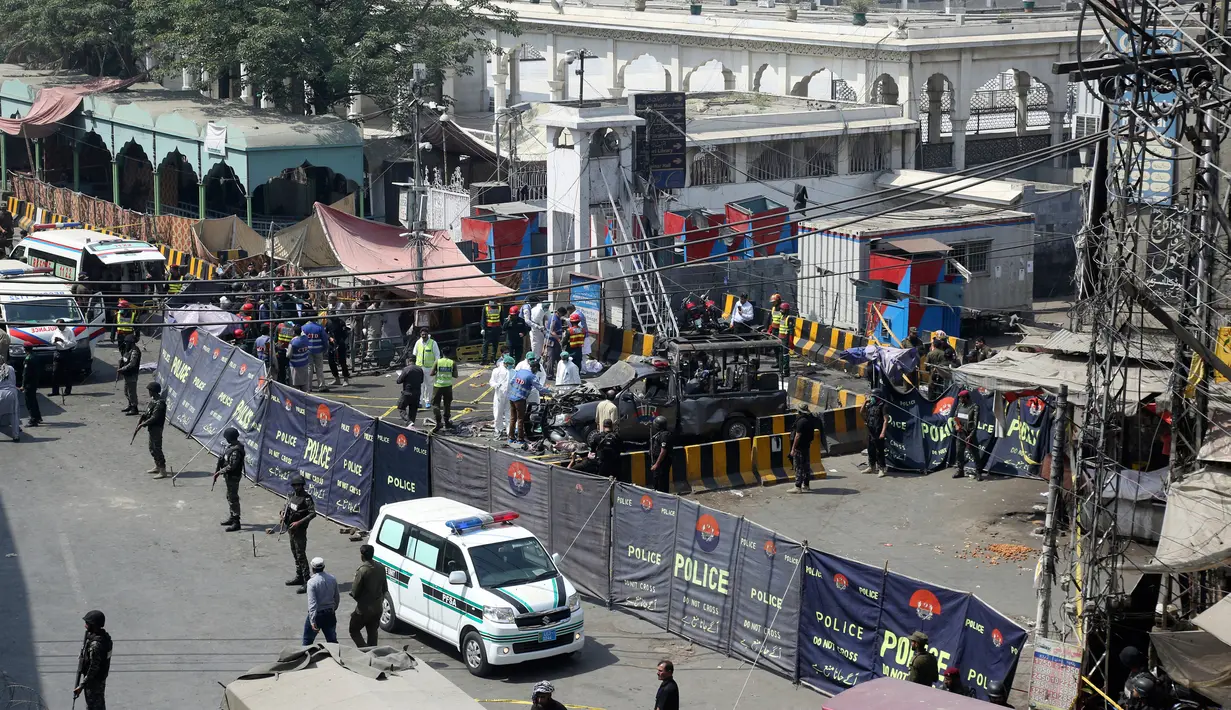 Petugas keamanan menjaga mobil van polisi yang rusak usai ledakan bom di luar tempat suci umat muslim Sufi, Lahore, Pakistan, Rabu (8/5/2019). Seorang petugas kepolisian lokal, Muhammad Kashif mengatakan ledakan tersebut kemungkinan menargetkan kendaraan petugas keamanan. (AP Photo/K.M. Chaudary)