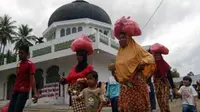 Warga membawa bungkusan sembako bantuan Polda Aceh saat bhakti sosial rencong di Desa Lamkabeu, Seulimum, Aceh Besar. Dalam bhakti sosial itu, Polda Aceh juga memberikan pengobatan gratis.(Antara)