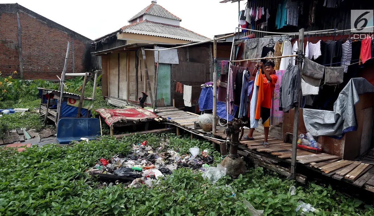 Warga menjemur pakaian di belakang rumah di kawasan Kampung Apung, Jakarta, Senin (6/11). Meski kampung tersebut terendam sejak tahun 1990-an, hingga kini warga masih tetap bertahan. (Liputan6.com/JohanTallo)