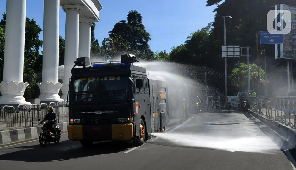 Petugas kepolisian Polresta Bogor menyemprotkan cairan disinfektan menggunakan mobil Water Cannon di kawasan Tugu Kujang, Bogor, Selasa (31/3/2020). Penyemprotan disinfektan secara menyeluruh di wilayah Kota Bogor itu guna mencegah memutus rantai penyebaran virus corona. (merdeka.com/Arie Basuki)