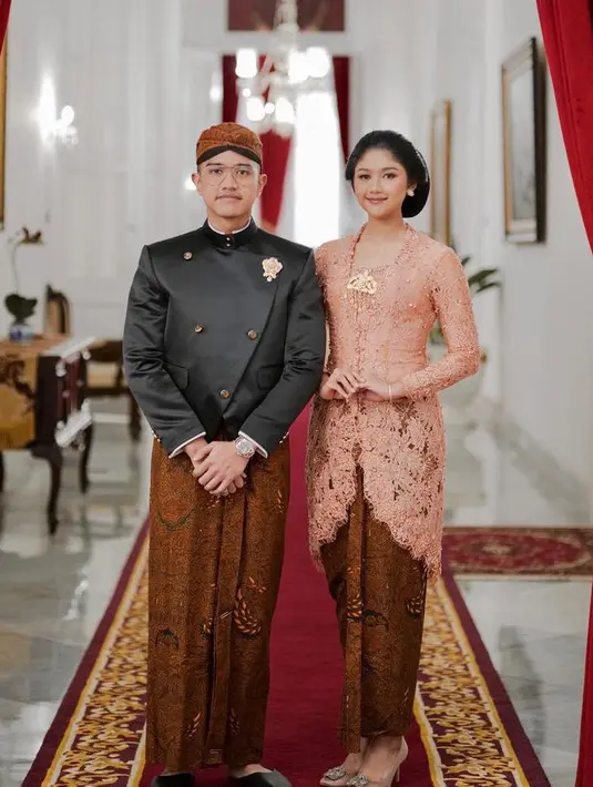 Erina Gudono mengenakan kebaya pink dipadukan kain batik lilit sebagai bawahan serasi dengan Kaesang yang mengenakan beskap hitam. [@erinagudono]