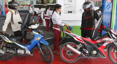 Petugas dengan pakaian adat mengisi bahan bakar minyak (BBM) untuk sepeda motor di SPBU, Bali, Rabu (10/10). Petugas SPBU mengenakan pakaian adat Bali untuk menyambut pertemuan tahunan IMF dan Bank Dunia. (Liputan6.com/Angga Yuniar)