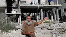  Seorang pria tampak menunjukkan rumahnya yang tak luput dari gempuran Israel pada Sabtu (02/08/14) (REUTERS/Ibraheem Abu Mustafa)