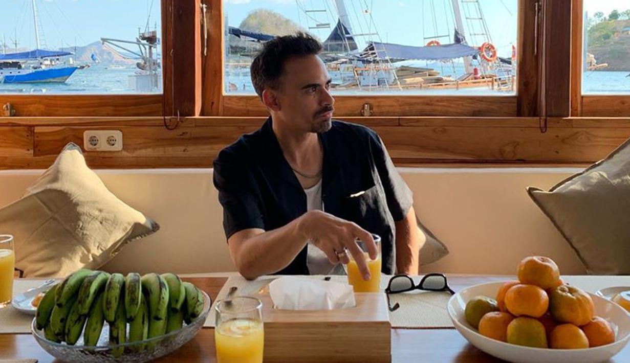 Saat liburan di Labuan Bajo, bapak satu anak ini tampil kasual dengan memakai kemeja biru dongker dan kaus putih. Di sela kesibukannya, Ashraf tetap meluangkan waktunya untuk keluarga. (Liputan6.com/IG/@ashrafsinclair)