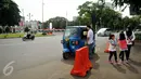 Penumpang turun dari angkutan umum jenis bajaj di kawasan Monas, Jakarta, Rabu (20/7). Sudinhubtrans Jakarta Pusat segera menerapkan larangan bajaj melintas di Jalan Medan Merdeka Barat dan Medan Merdeka Utara. (Liputan6.com/Gempur M Surya)