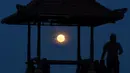 Siluet gazebo terlihat dengan latar belakang supermoon di Pantai Sanur, Bali, Senin (14/11). Fenomena ini terjadi saat bulan mencapai titik terdekat dengan bumi dan merupakan fenomena supermoon terbesar dalam 68 tahun terakhir. (SONNY TUMBELAKA/AFP)