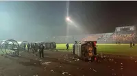 Mobil pihak keamanan sampai terbalik saat terjadinya kericuhan usai pertandingan antara Arema FC versus Persebaya di Liga 1 2022/2023 hari Sabtu (01/10/2022). (Iwan Setiawan/Bola.com)