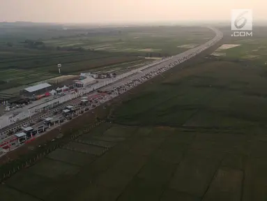Foto udara antrean kendaraan pemudik di jalur tol fungsional Gerbang Tol (GT) Kertasari, Tegal, Jawa Tengah, Minggu (10/6). Memasuki H-5 lebaran GT Kertasari mulai dipadati kendaraan pemudik dari arah Jakarta. (Liputan6.com/Arya Manggala)