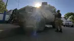 Seorang polisi nasional berbicara dengan rekan-rekannya di samping mobil polisi lapis baja di Port-au-Prince, Haiti, Sabtu (21/1/2023). Salah satu geng Haiti menyerbu bagian penting ibu kota, Port-Au-Prince, dan bertempur dengan polisi sepanjang hari, menyebabkan setidaknya tiga petugas tewas dan satu lainnya hilang. (AP Photo/Megan Janetsky)