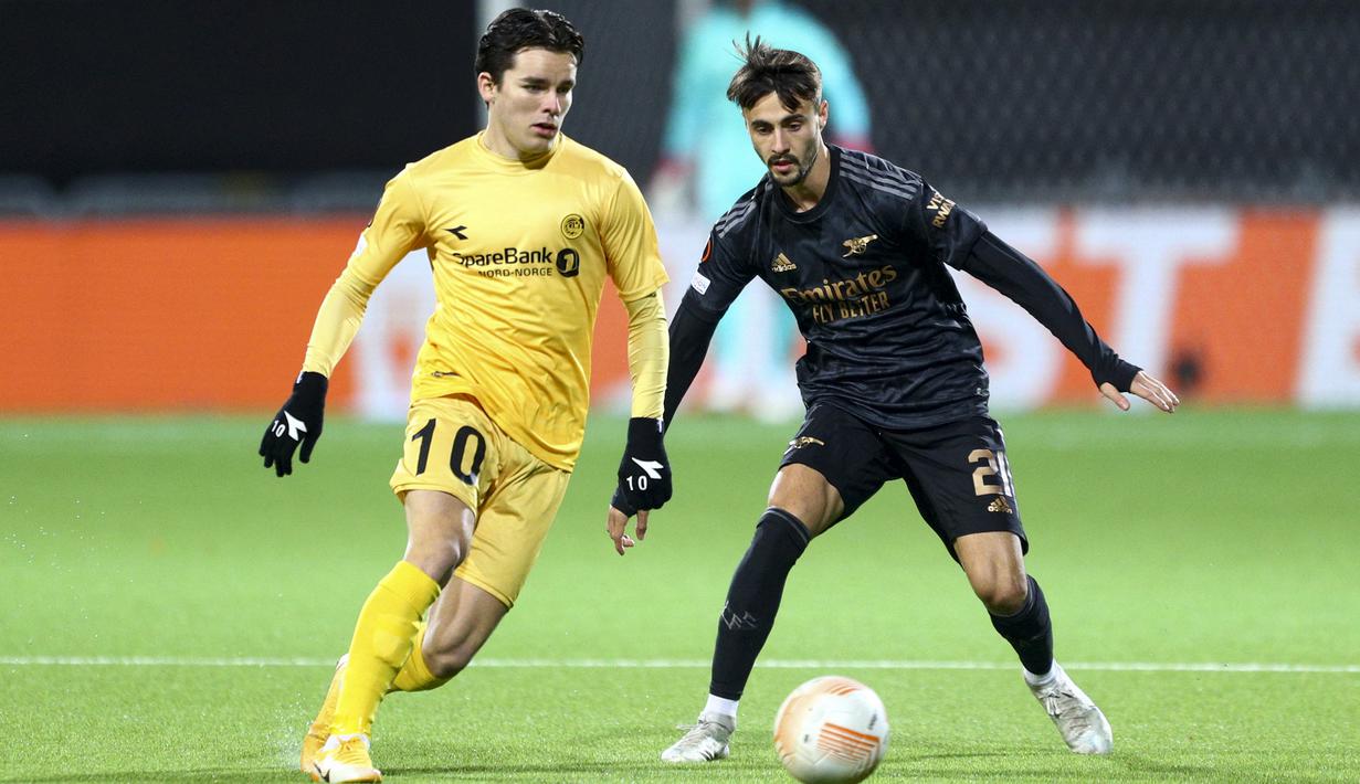 Gelandang Bodo/Glimt Hugo Vetlesen (kiri) dan gelandang Arsenal Fabio Vieira berebut bola pada pekan ke-4 Grup A Liga Europa 2022/2023 di Aspymra Stadion, Norwegia, Kamis malam (13/10/2022). Hasil ini membuat Arsenal masih kokoh bercokol di papan klasemen sementara dengan sembilan poin. (Photo by Mats Torbergsen / NTB / AFP)
