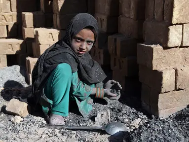 Seorang anak mengumpulkan sisa batu bara yang digunakan di pabrik batu bata di pinggiran Kabul, Afghanistan, Rabu (12/6/2019). Ribuan anak Afghanistan bekerja mencari uang untuk menghidupi keluarga mereka. (AP Photo/Rahmat Gul)