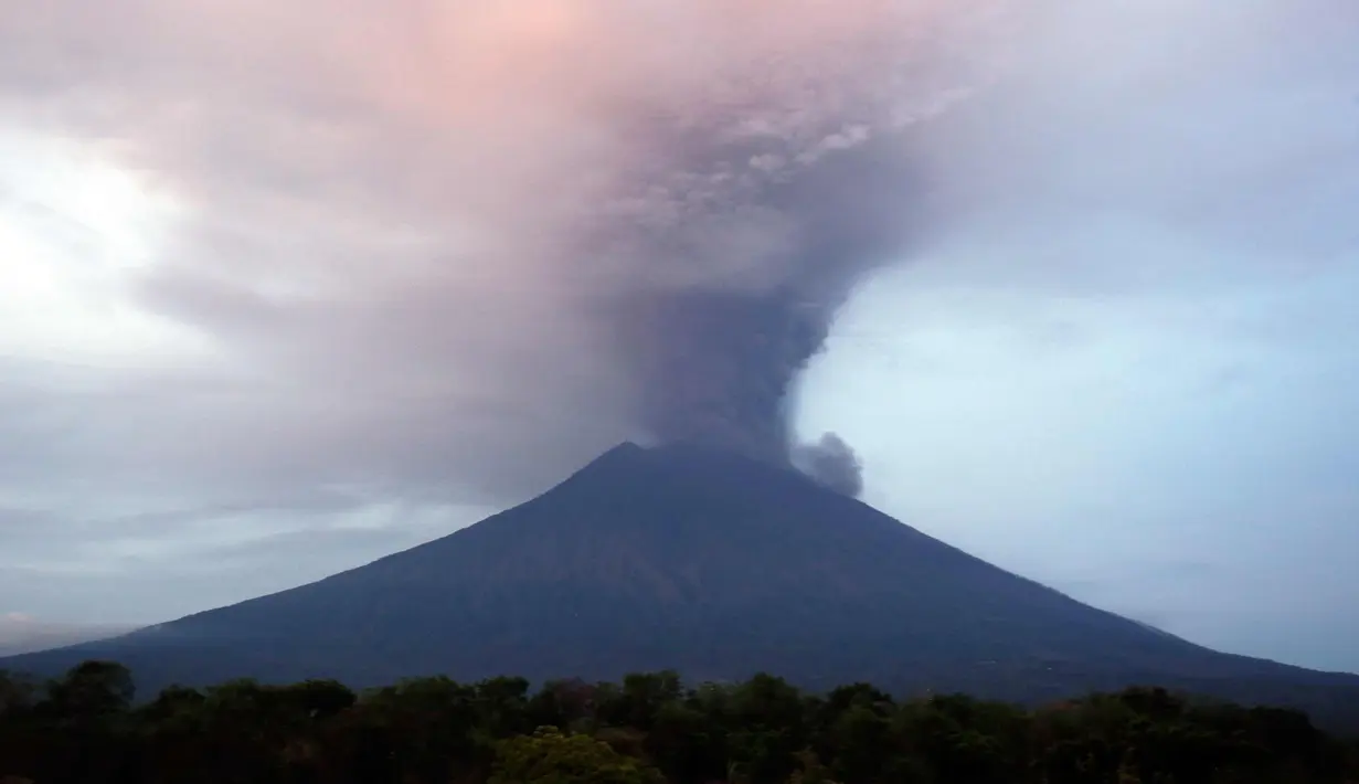 Semburan abu vulkanik Gunung Agung terlihat dari sebuah desa di Kecamatan Kubu, Karangasem, Bali, (27/11). Semburan asap dan abu vulkanik Gunung Agung mencapai ketinggian 1.500 meter dari puncak Gunung Agung. (AP Photo / Firdia Lisnawati)