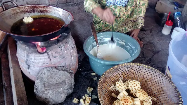 Nampak sebuah wajah penggorengan, bahan adonan dan beberapa kue seroja siap santap dalam proses pembuatan kue seroja di Garut