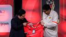 Ketua Umum PSSI, Erick Thohir (kiri) memberikan jersey Timnas Indonesia bertanda tangan pelatih baru John Herdman kepada Ketua Steering Committee (SC) Piala Presiden 2025 dalam acara Malam Penutupan Piala Presiden 2025 di Studio 8 SCTV Tower, Senayan City, Minggu (12/04/2026) malam WIB. (Bola.com/Bagaskara Lazuardi)