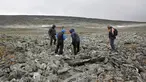 Arkelolog dan dua pemburu yang menemukan sebilah pedang milik bangsa Viking menelusuri sebuah gunung di Norwegia, 4 September 2017. Pedang dari bangsa Viking itu ditemukan pemburu rusa kutub, Einar Ambakk, saat berburu di antara bebatuan. (AP Photo)