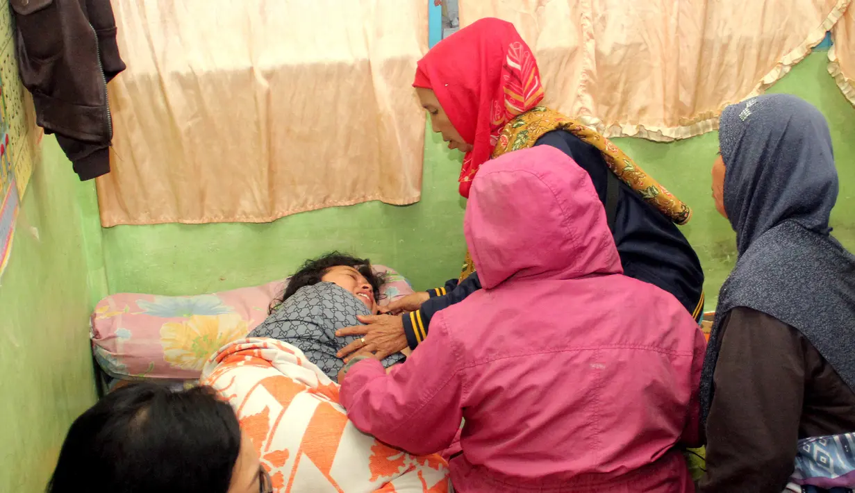 Keluarga menenangkan korban selamat KM Sinar Bangun yang tenggelam di Danau Toba, Sumatera Utara, Senin (18/6). Hingga saat ini, Posko Pengaduan Pelabuhan Simanindo mencatat 53 orang masih belum diketahui keberadaannya. (AFP Photo/Lazuardy Fahmi)